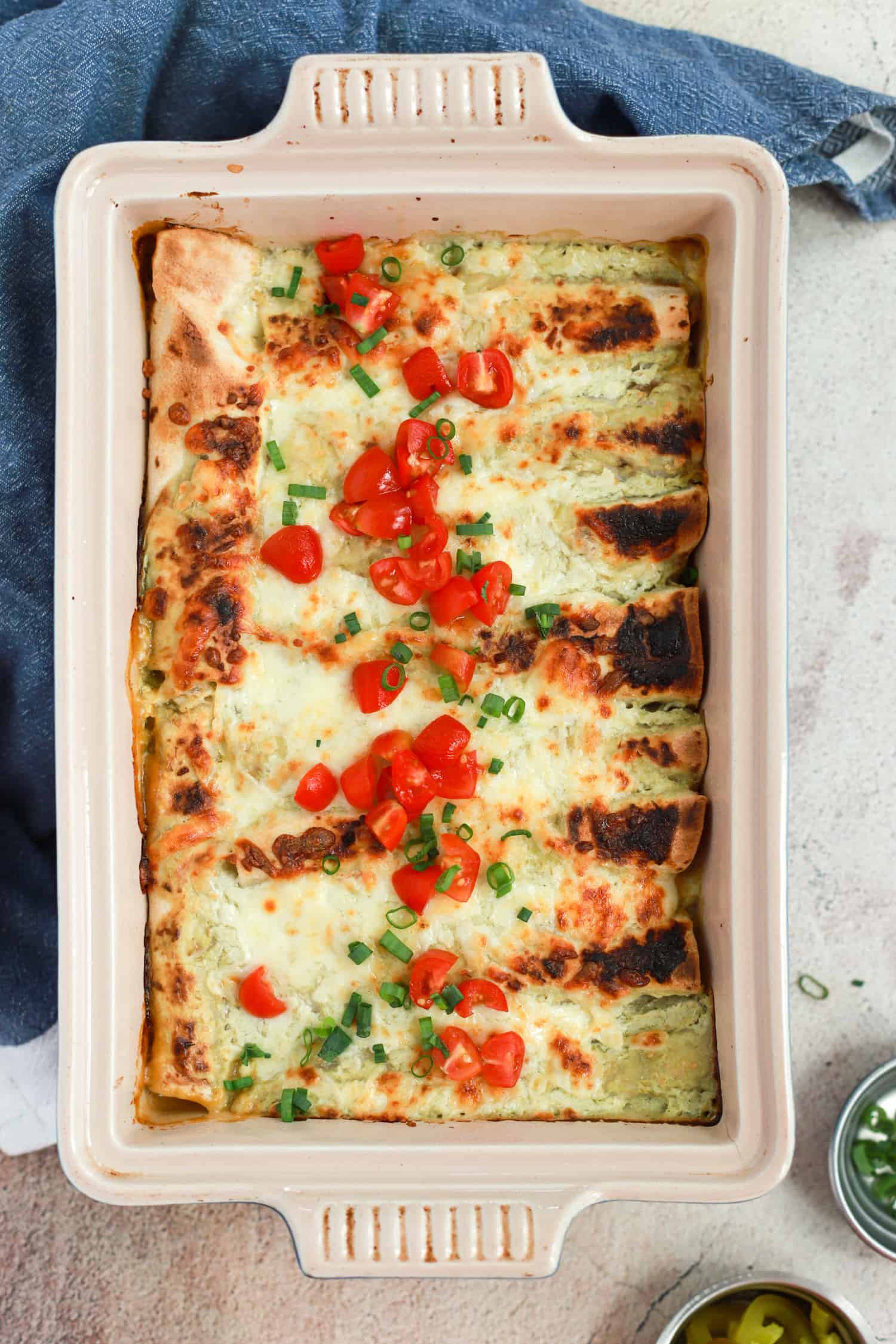 Large rectangular baking dish of green chicken enchiladas.