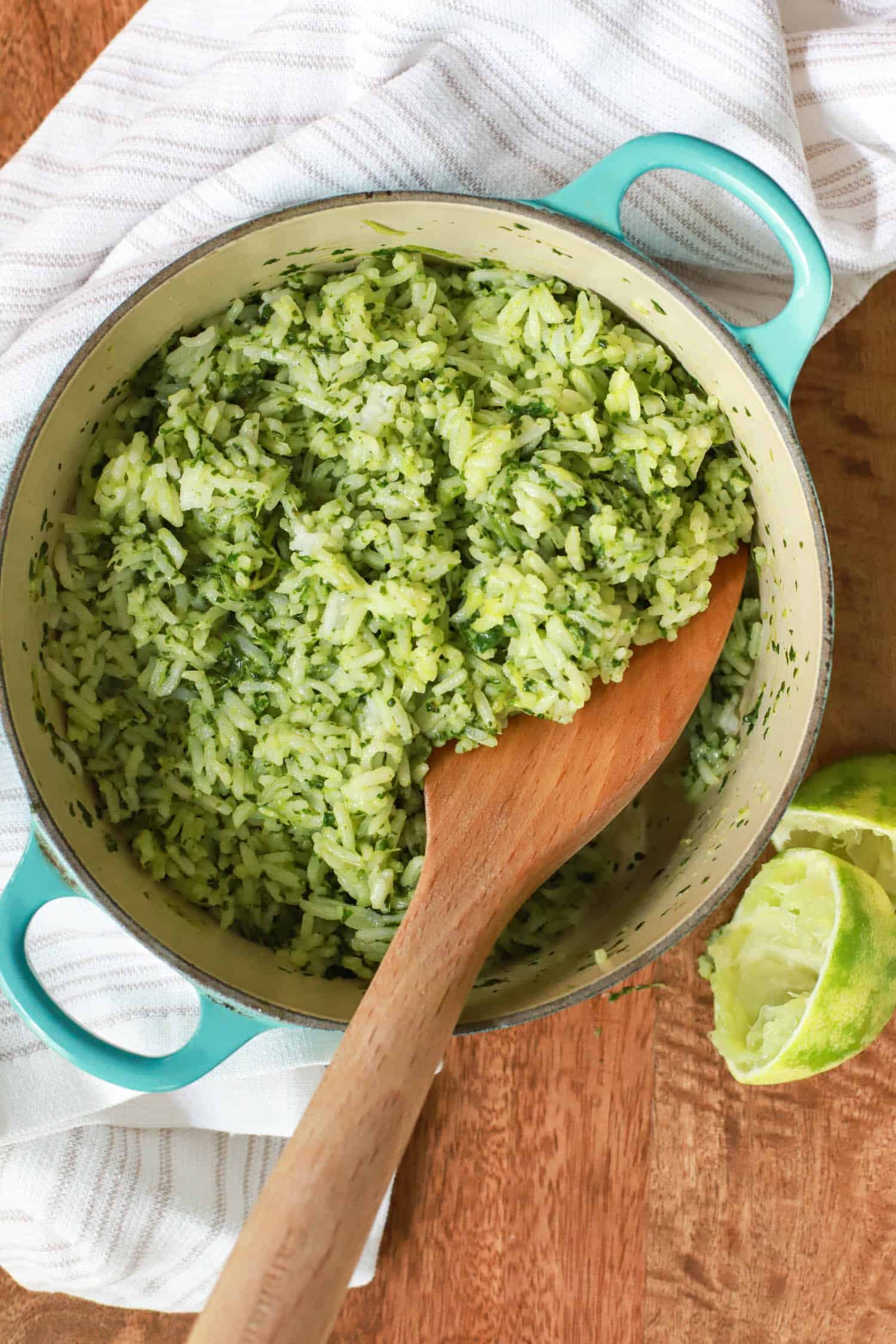 Small blue pot of Mexican green rice with wooden rice paddle.