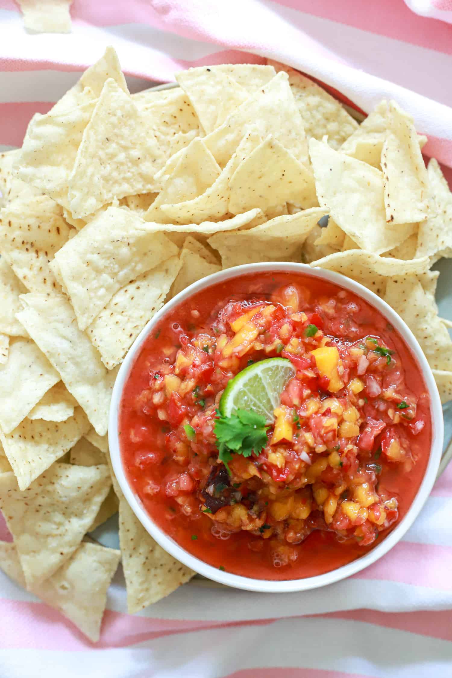 white bowl of peach salsa and chips.