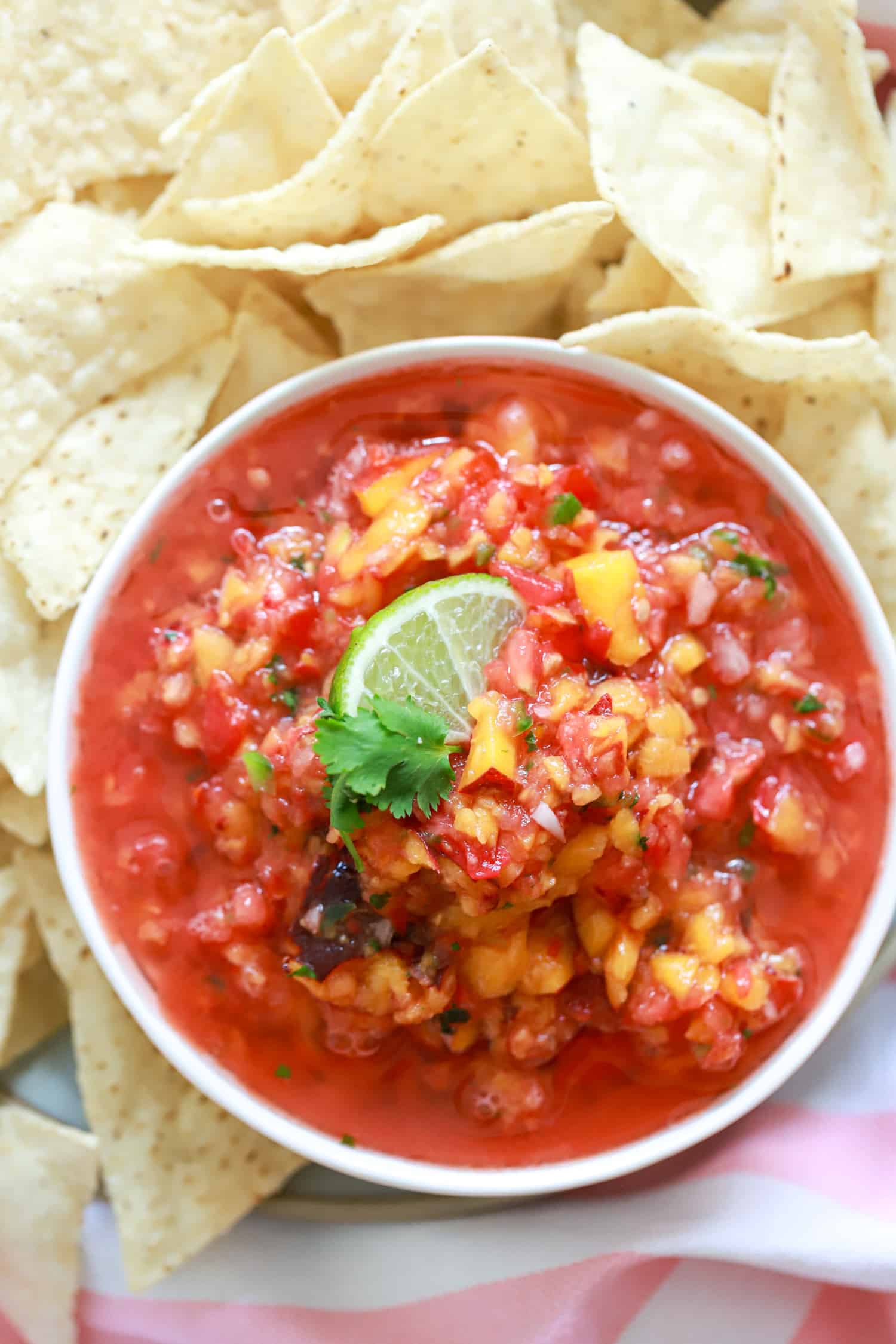 peach jalapeno salsa with pale white chips.