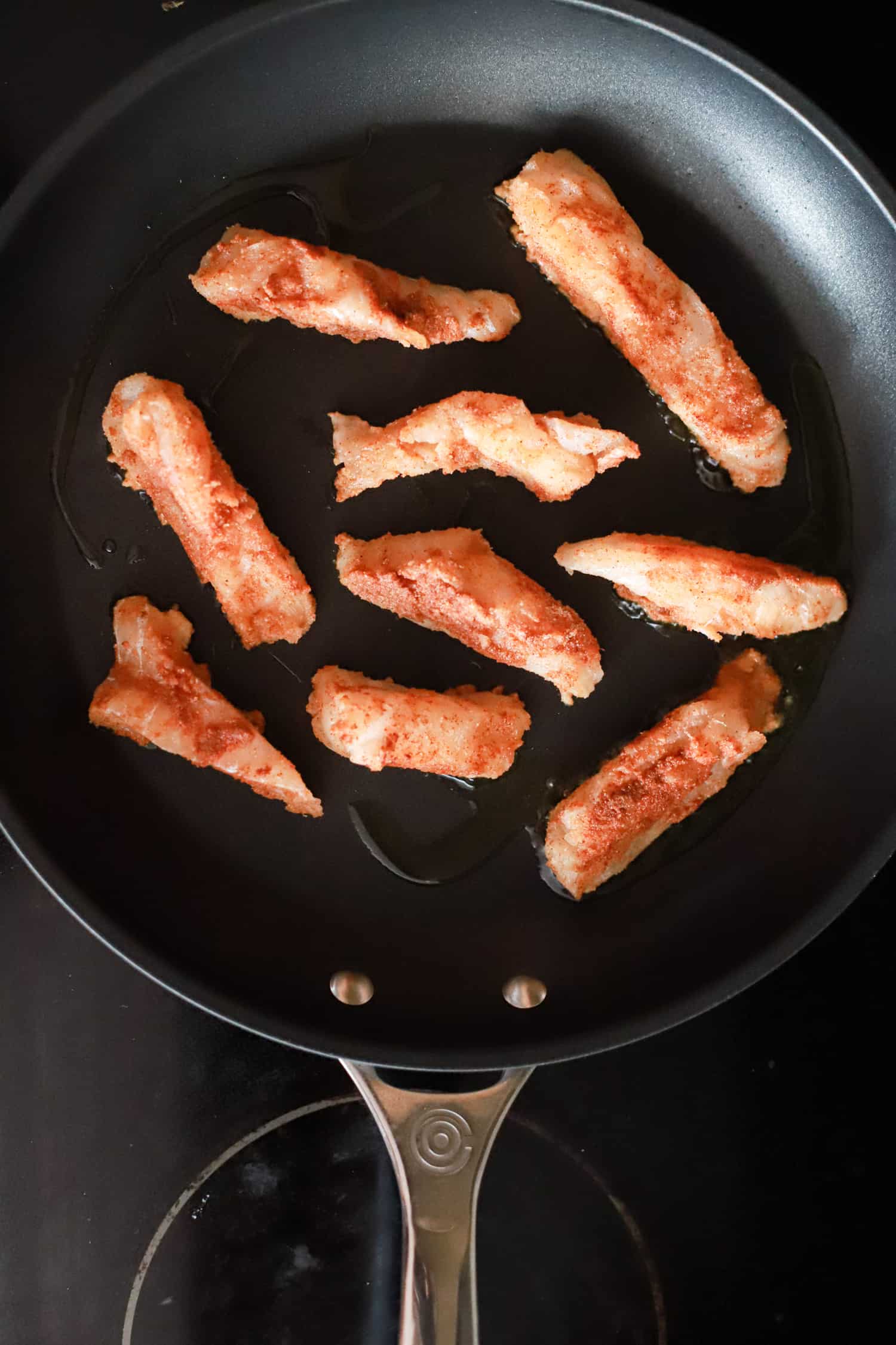 cod pieces for tacos in black skillet.