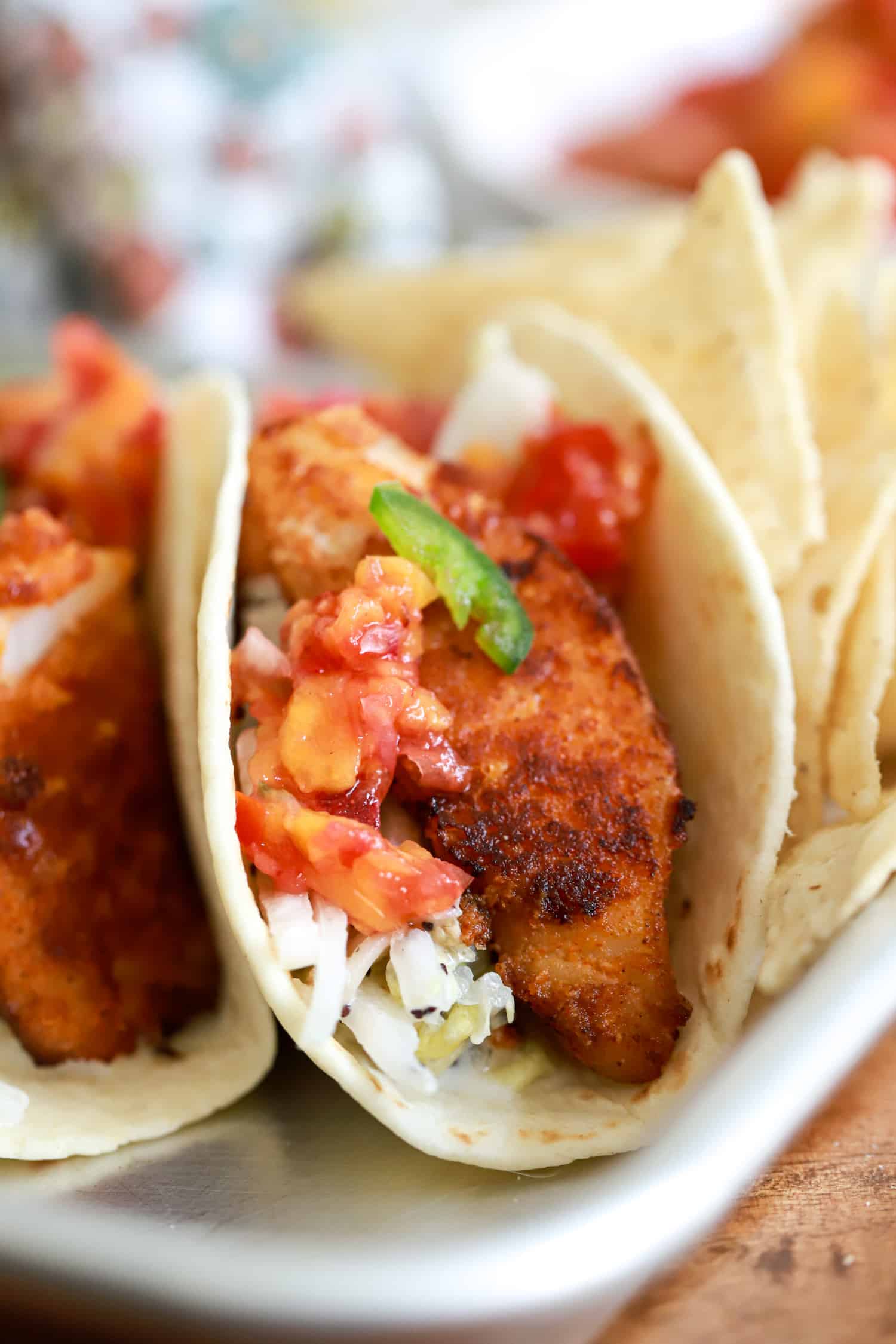 side view of crispy fish taco with slaw and salsa