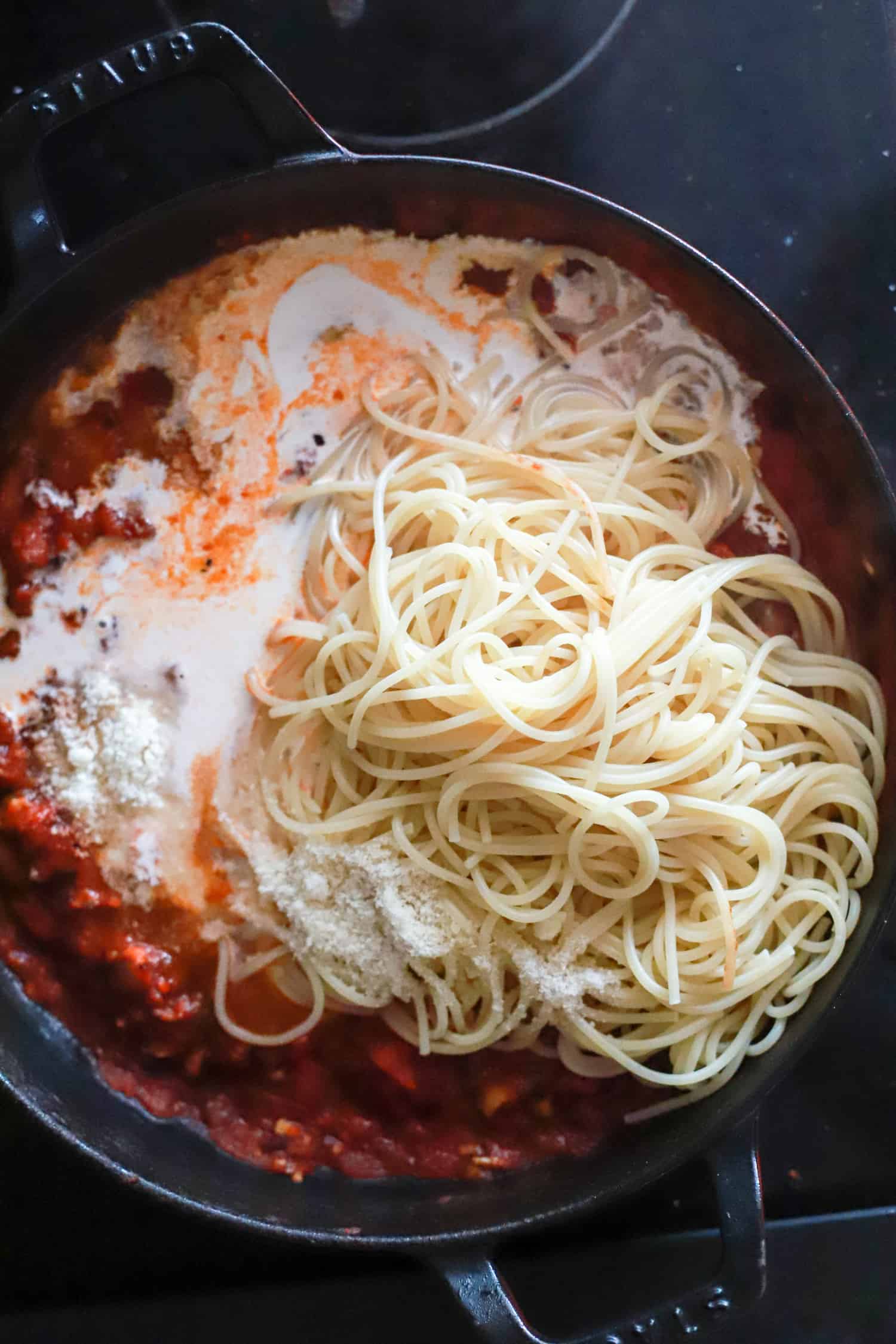 skillet with ingredients for creamy spaghetti.