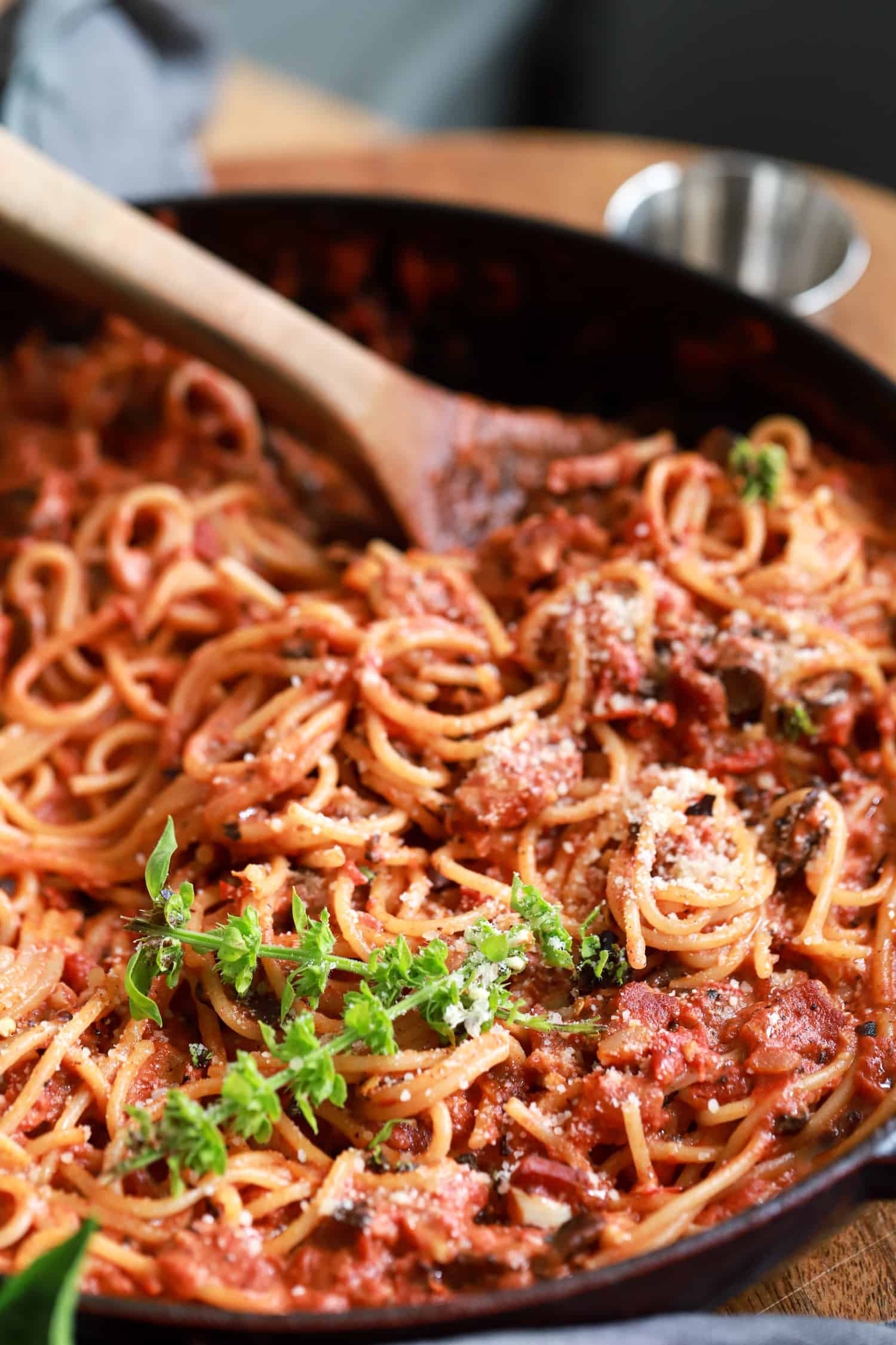 skillet with wooden spoon scooping mushroom pasta.