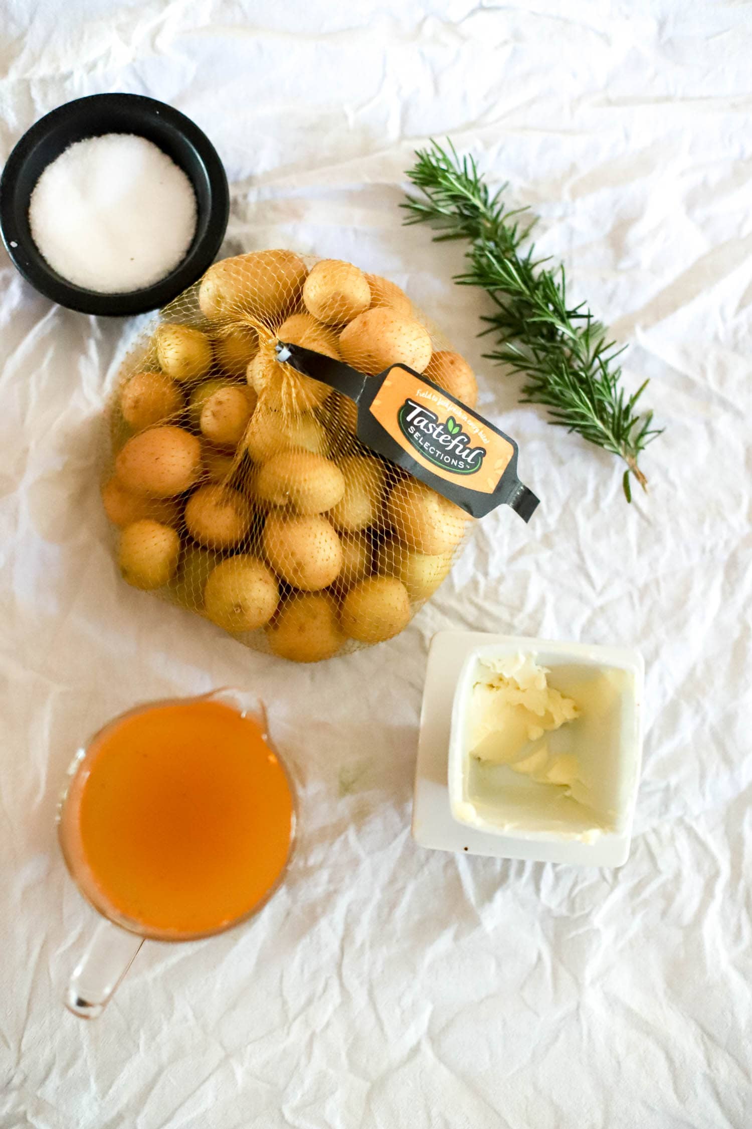 Ingredients for steamed baby potatoes on a white cloth.