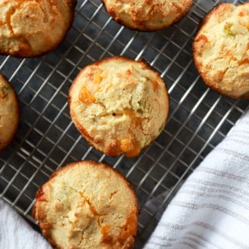 corn muffins on wire rack with white napkin at the edges.