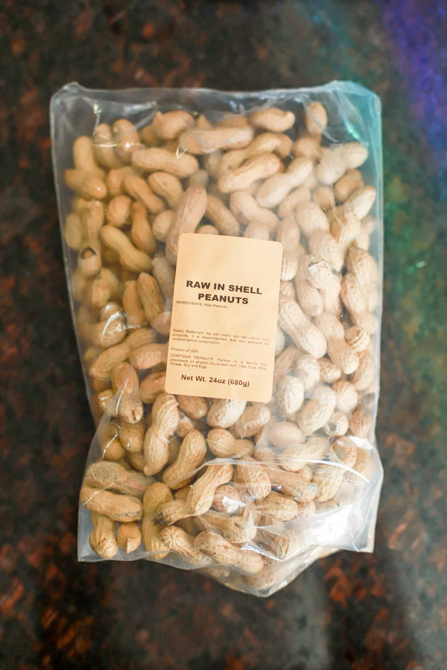 Large clear bag of raw peanuts in their shells.