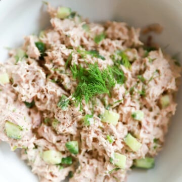 Close up top view of tuna salad with cucumber and dill.