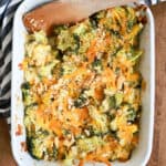 white baking dish with broccoli casserole and wooden spoon.