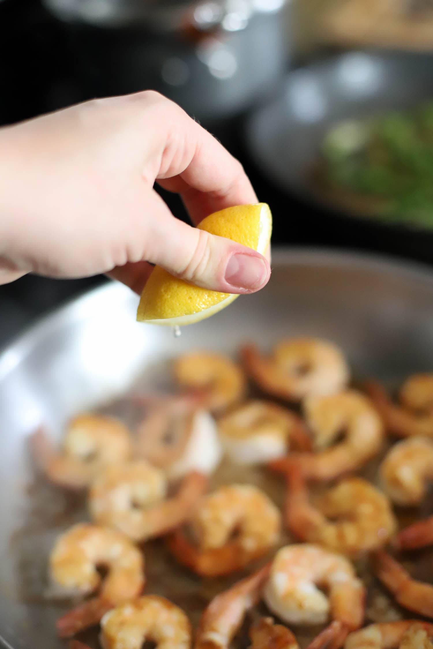 hand squeezing lemon juice for hibachi shrimp.