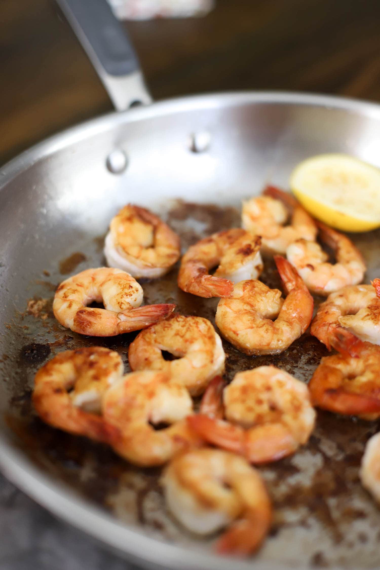 side angled view of browned shrimp in silver pan.