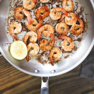 Silver pan of hibachi shrimp with lemon.