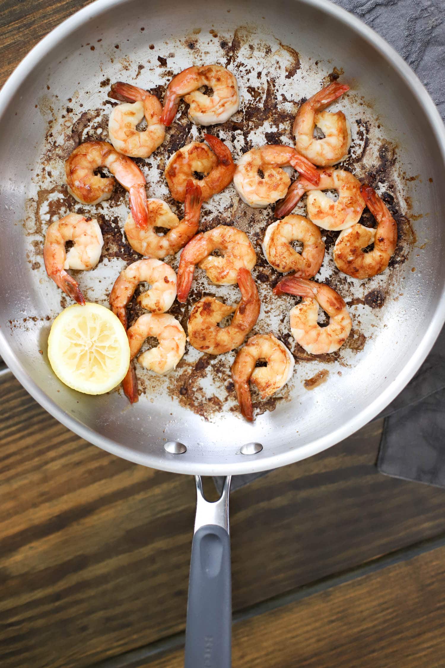 hibachi shrimp in skillet with squeezed lemon half.