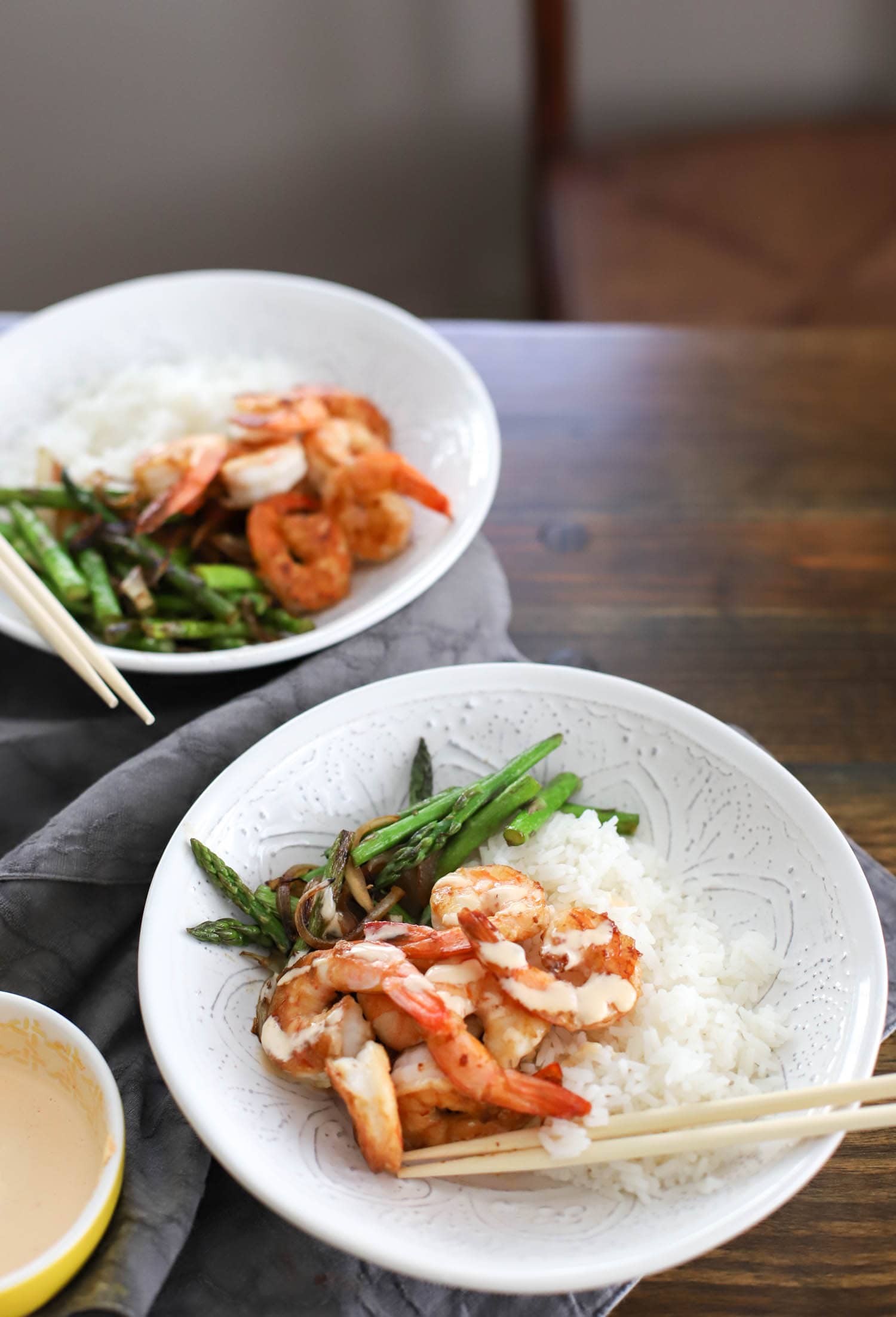 white shallow bowl with hibachi shrimp and vegetable meal over rice.