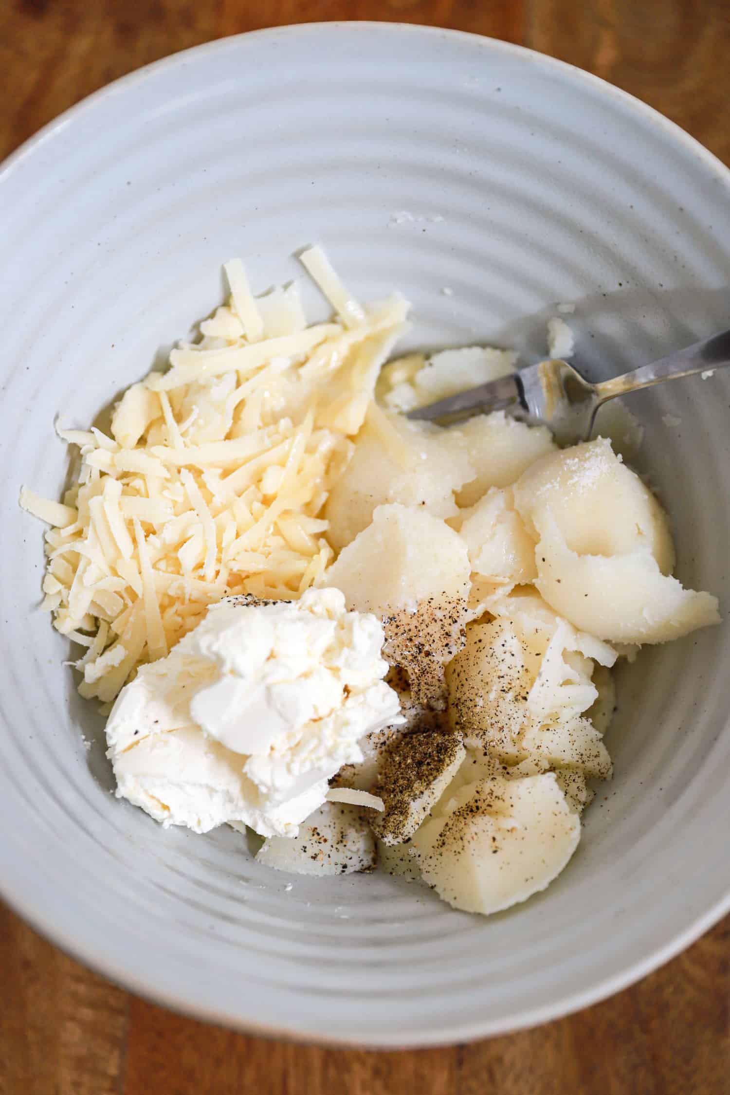 Ingredients for twice baked potatoes in a large ceramic bowl.