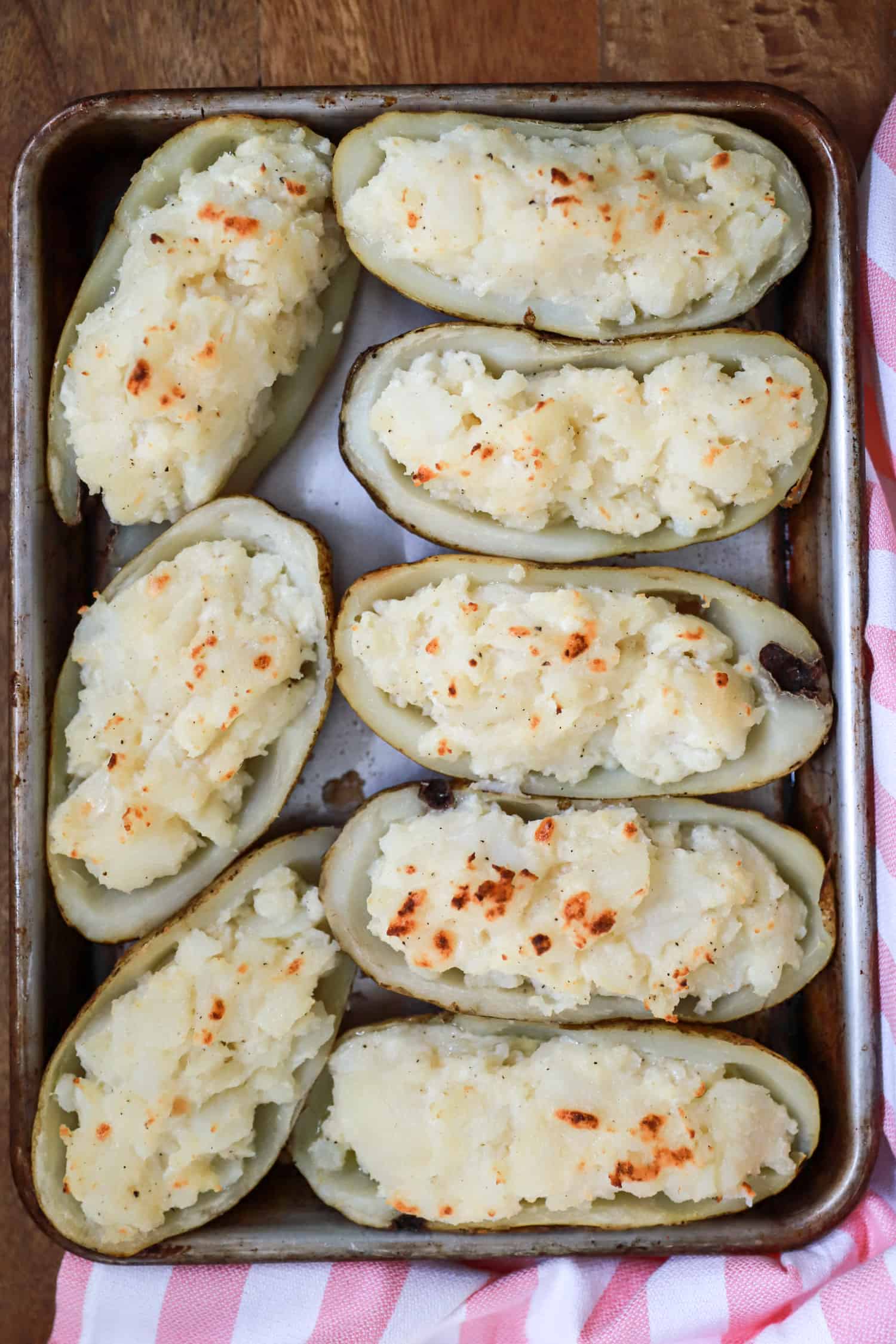 Cheesy twice baked potatoes on a baking sheet.