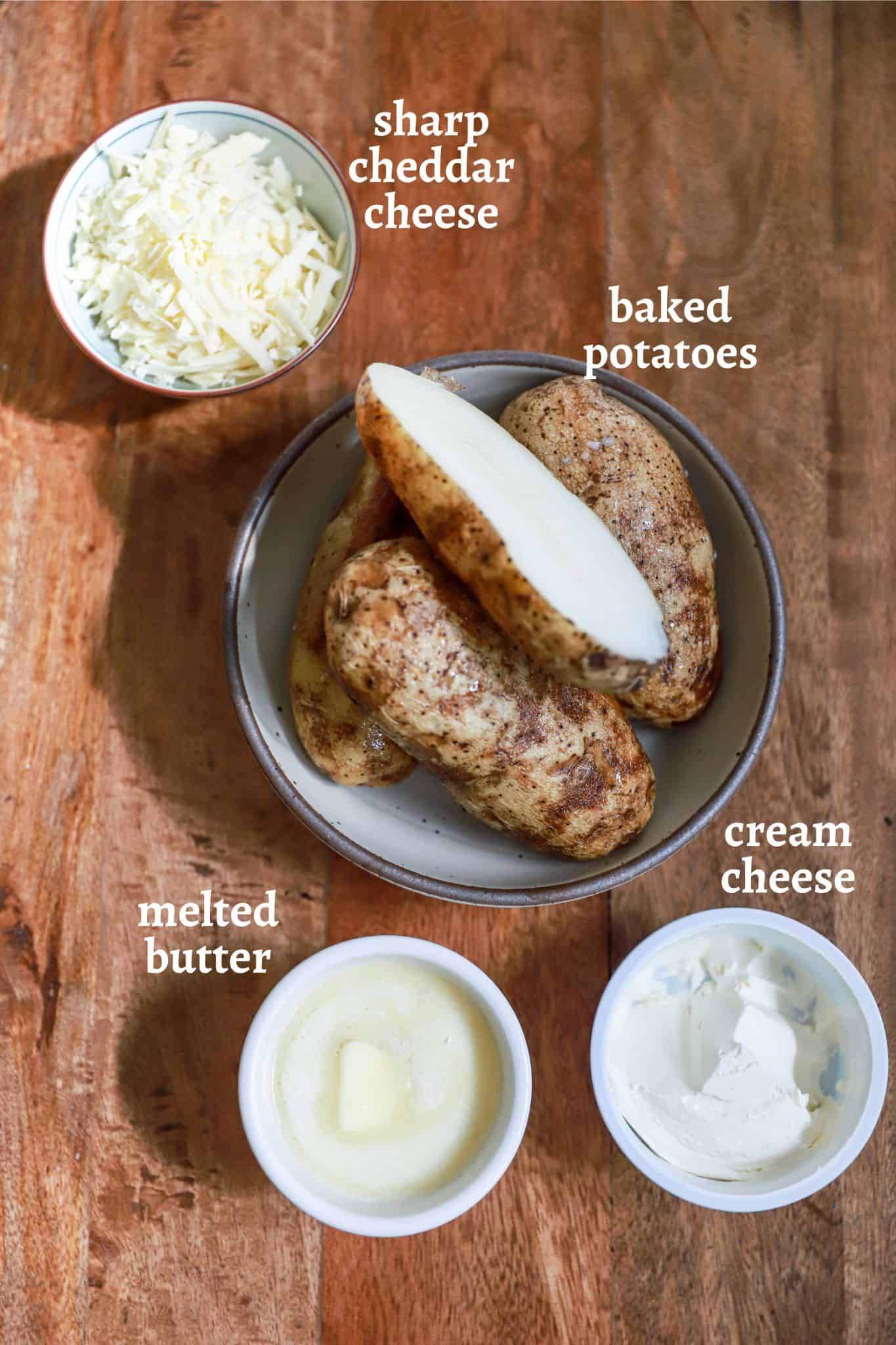 Ingredients for twice baked potatoes on a brown wooden board.