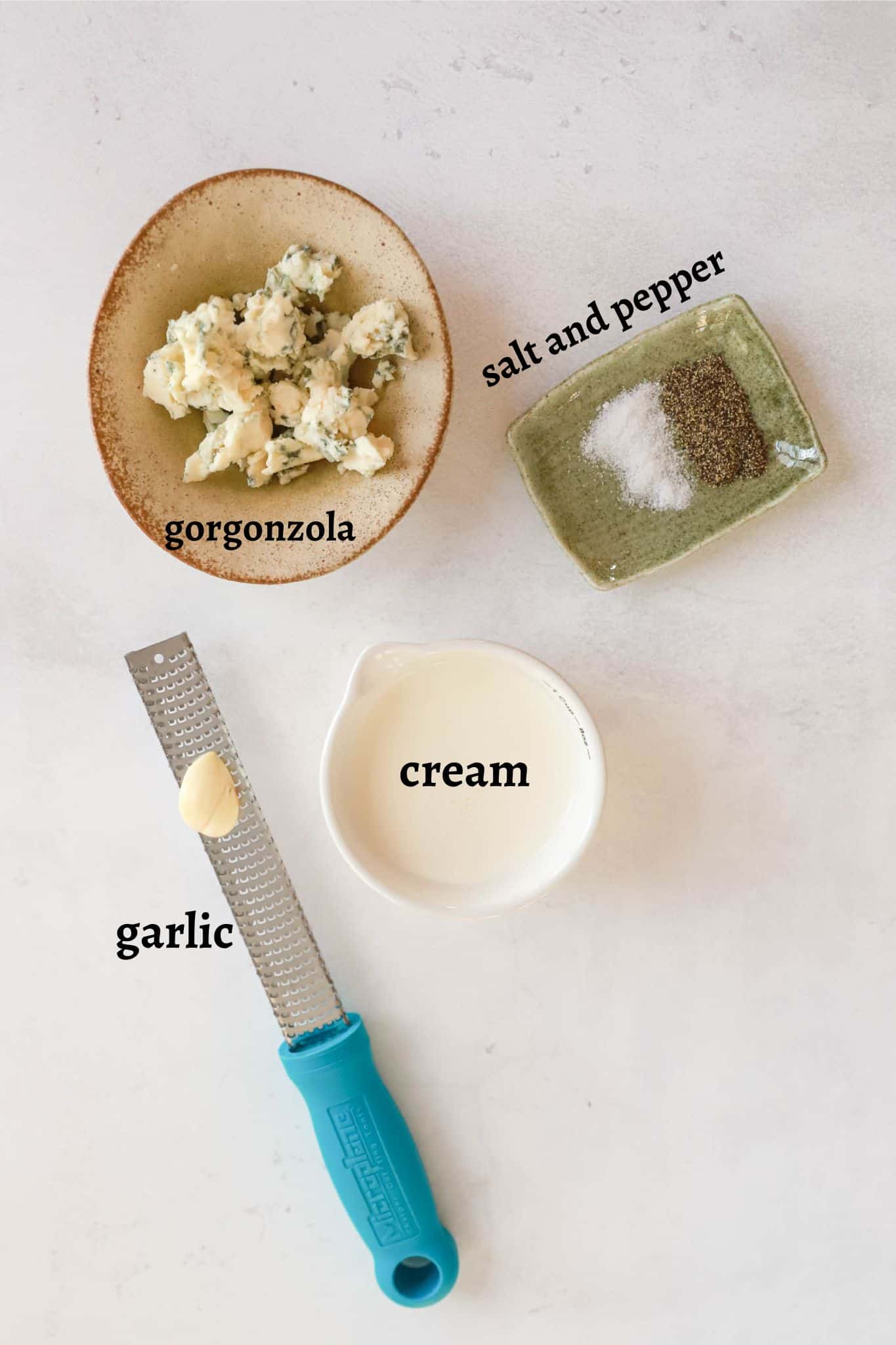 Ingredients for gorgonzola sauce labeled on a white background.