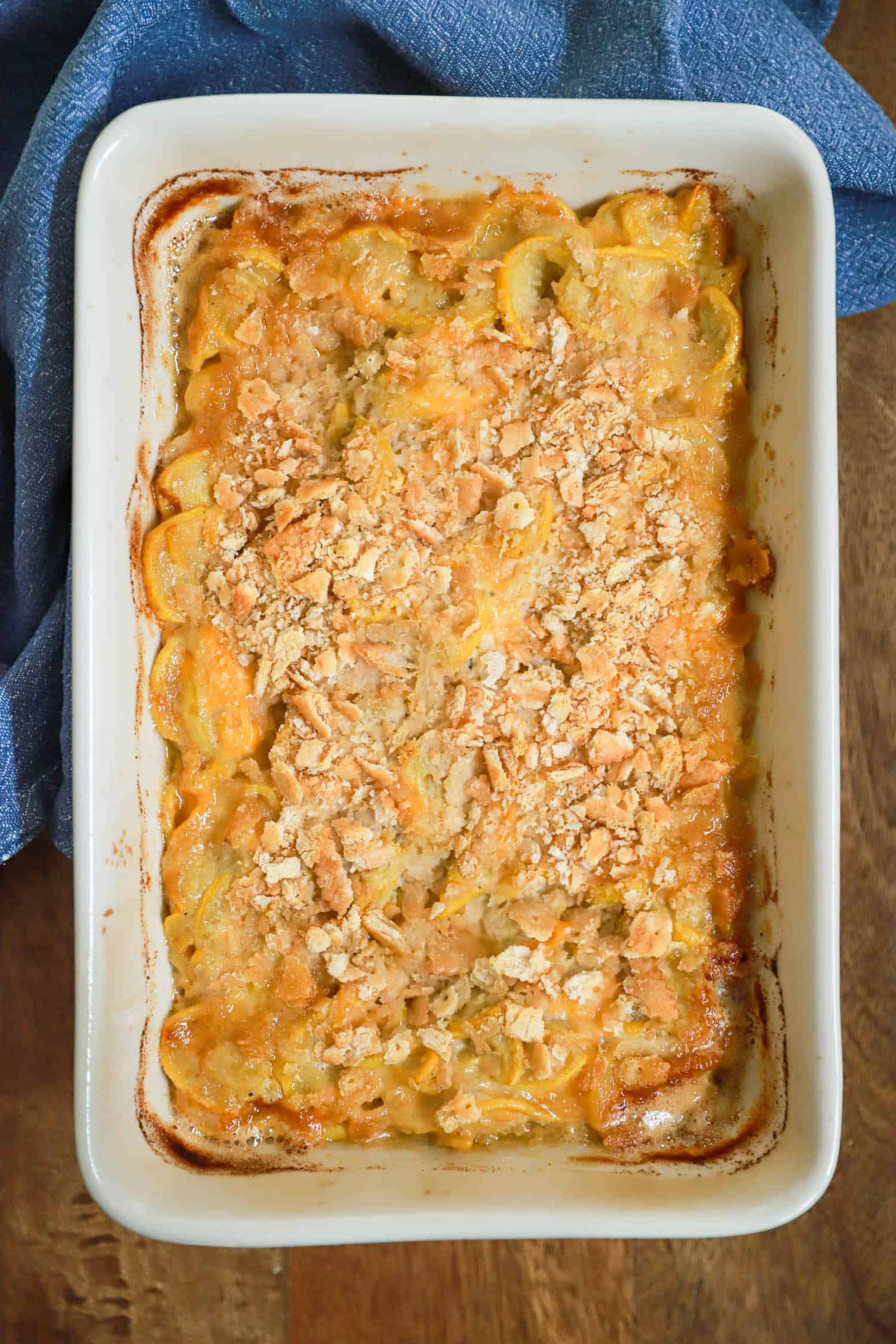 Top view of squash casserole with Ritz crackers in a large baking dish.