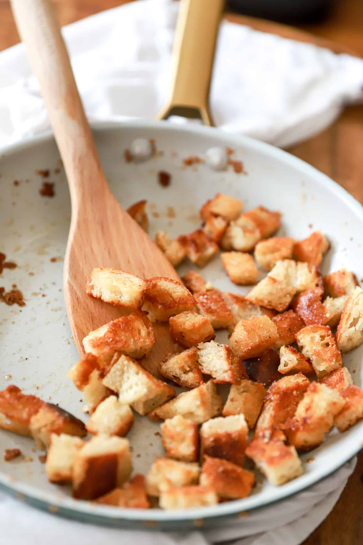 white skillet with homemade garlic bread croutons.