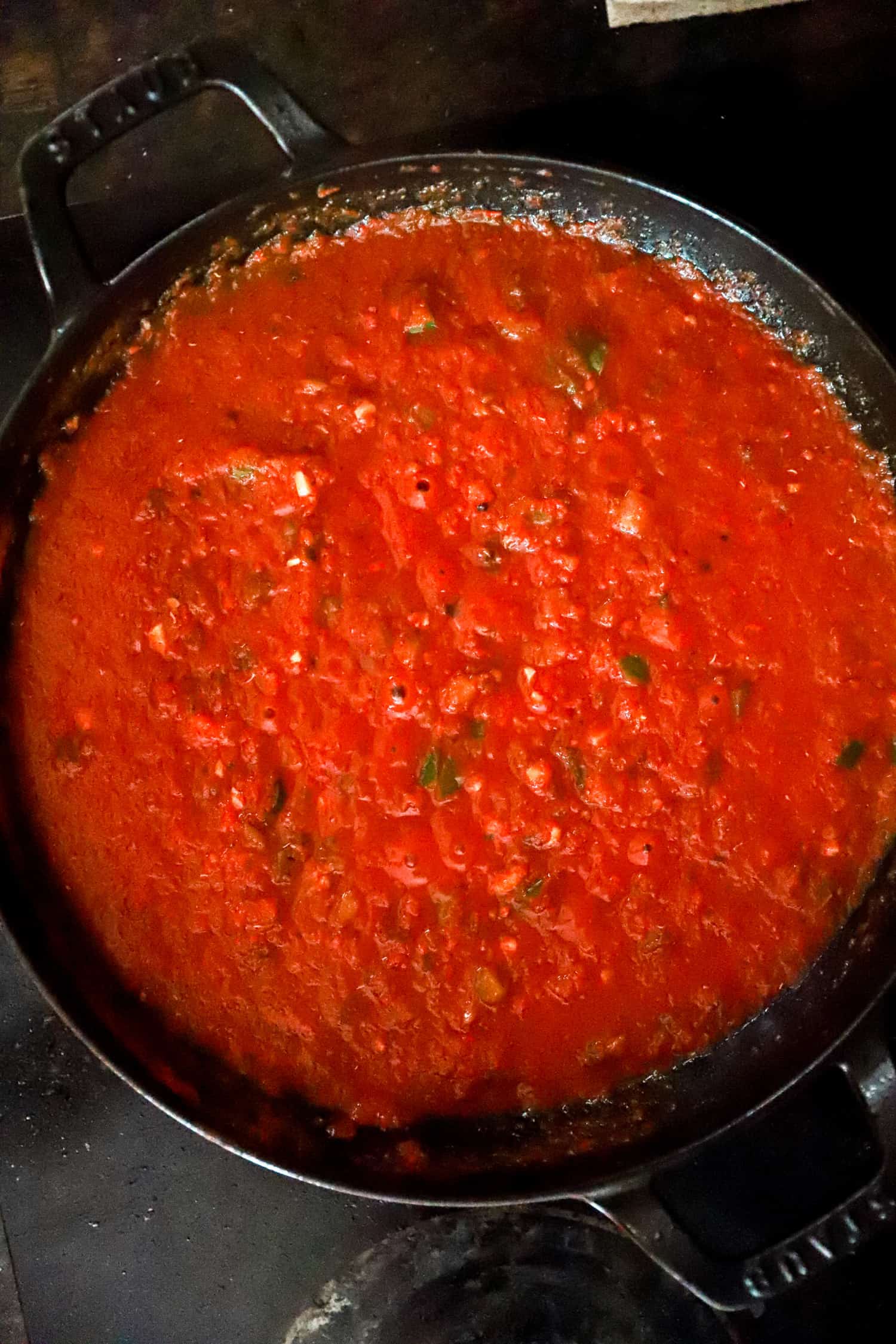 red tomato sauce simmering in a black skillet.