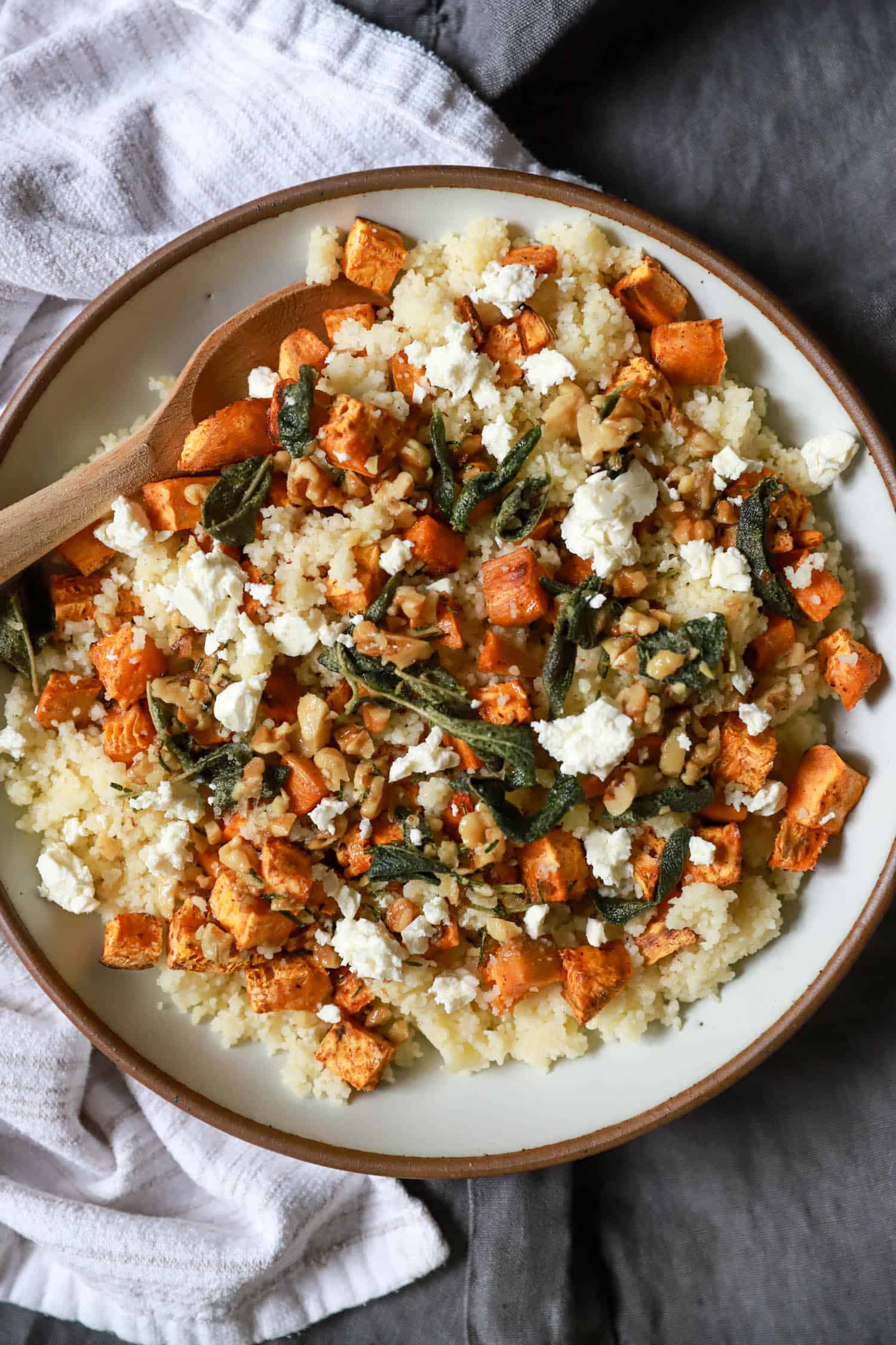 Platter of sweet potato couscous with crispy sage and feta cheese crumbles.
