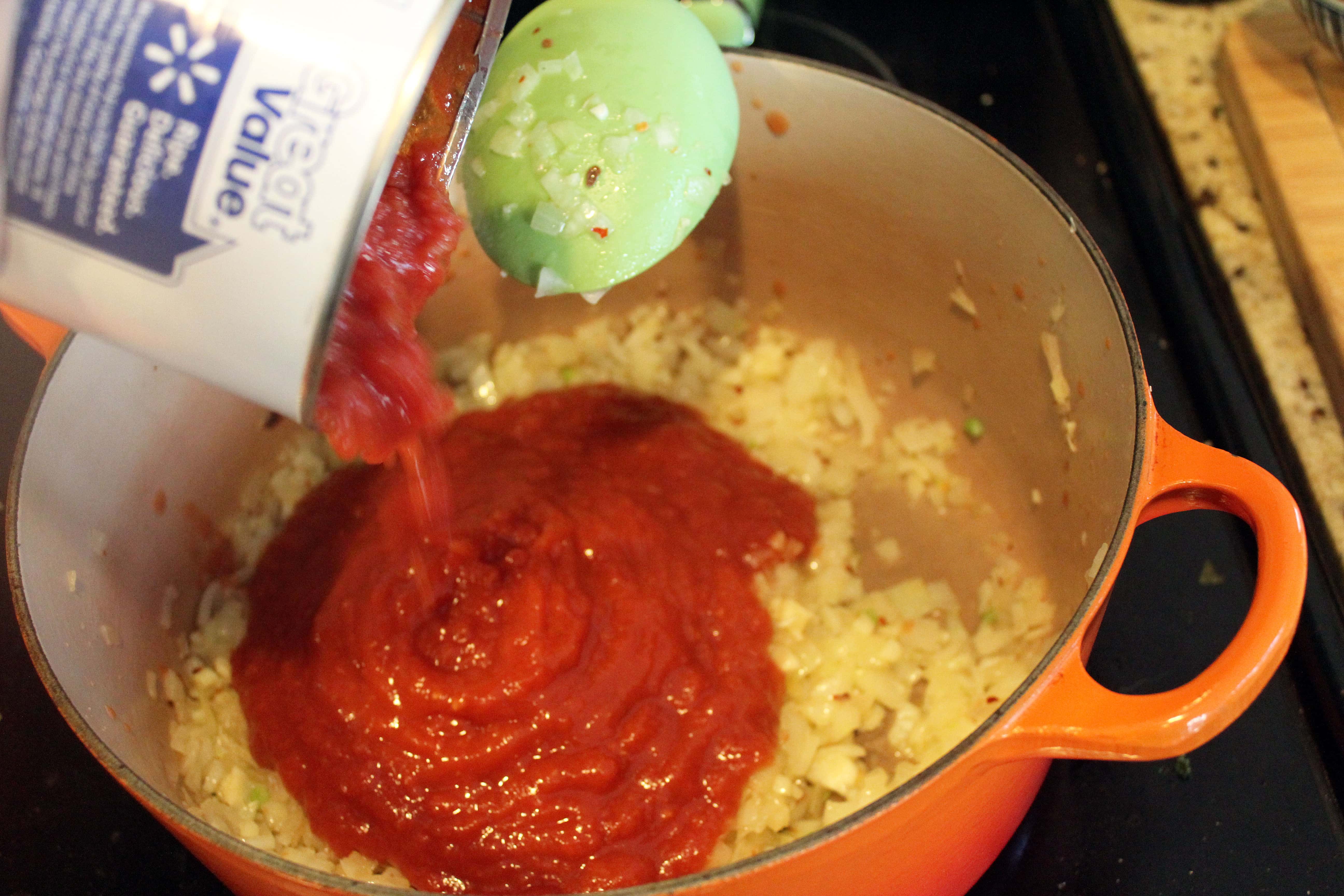 Add crushed tomatoes to onion