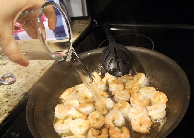 Add wine to half cooked shrimp