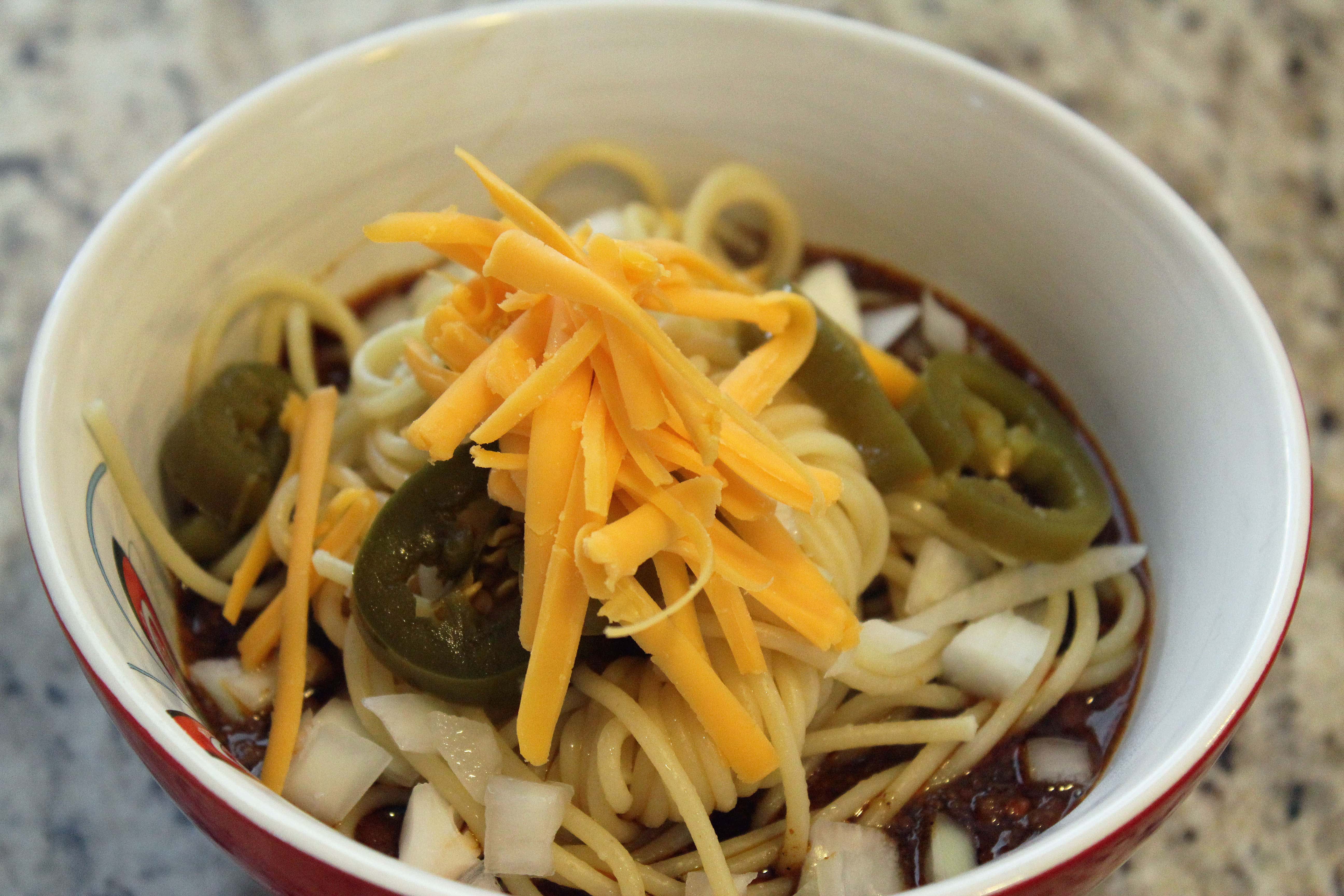 Top chili with pasta and toppings