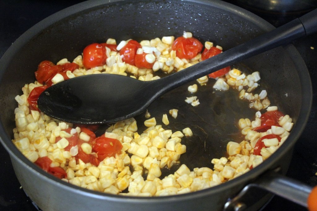 Add corn to tomatoes and stir