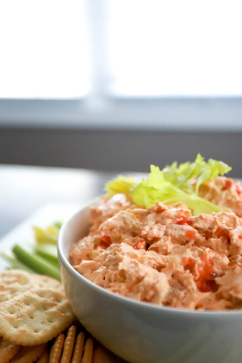 Side view of buffalo chicken salad topped with celery leaves.