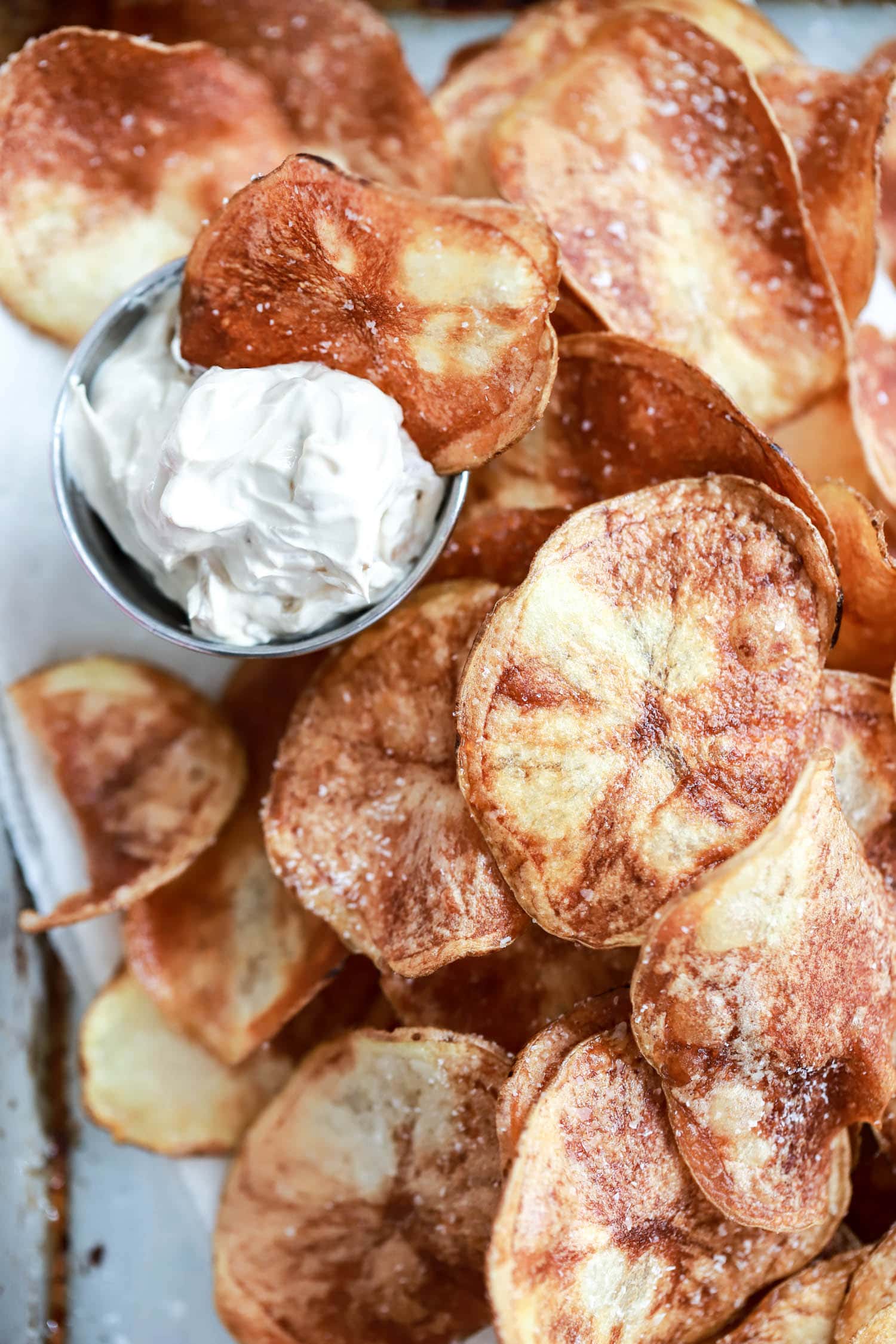 homemade potato chips dipped in ranch dip close up.