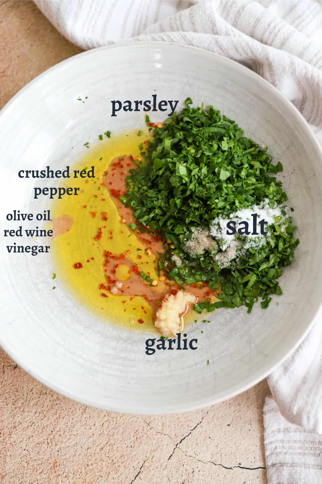 ingredients for homemade chimichurri in white shallow bowl.