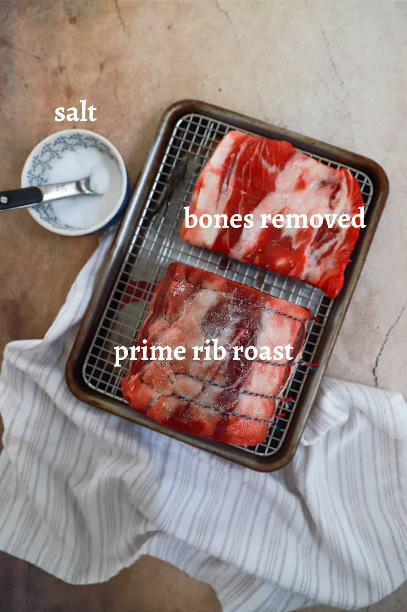 uncooked prime rib resting on a baking rack with salt.
