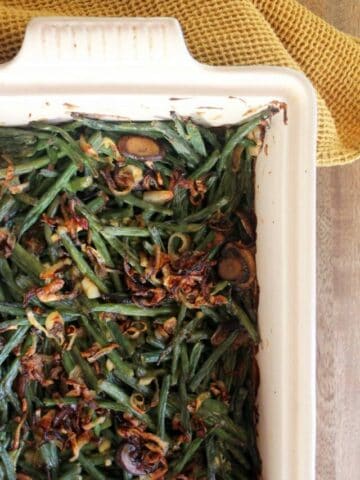 baking dish with cooked green bean casserole topped with shallots.