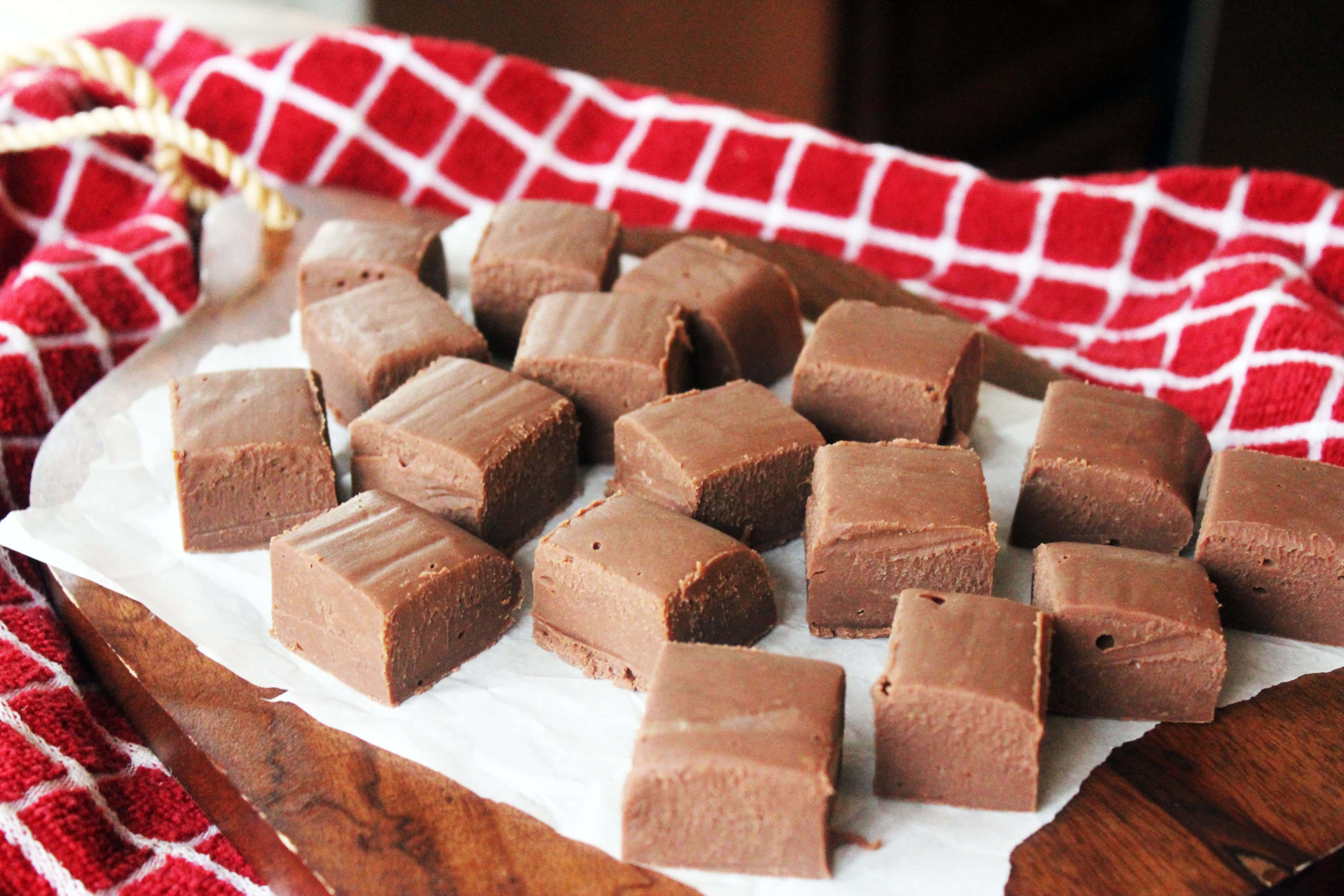 white parchment paper with small cubes of 2 ingredient fudge.