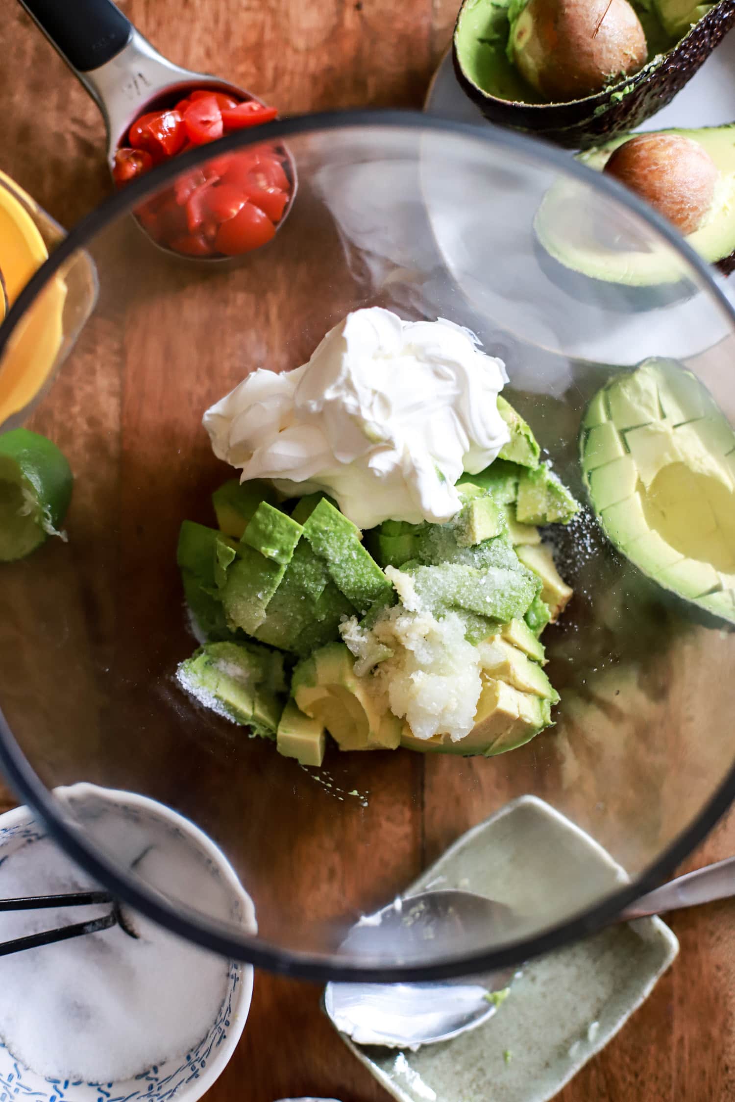 Sour Cream Guacamole ingredients in a large glass bowl.