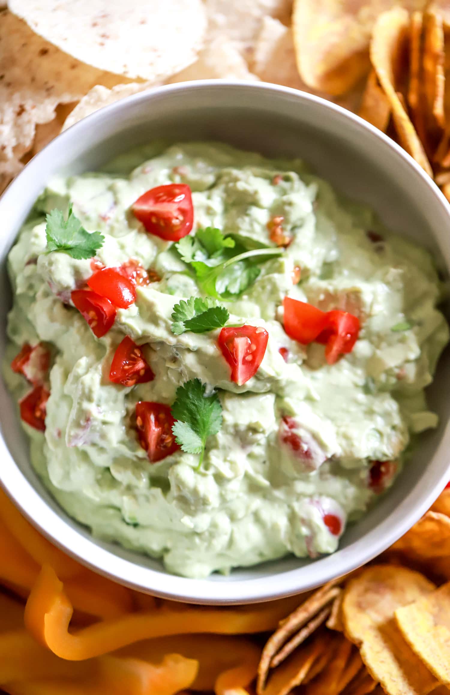 sour cream guacamole bowl topped with tomatoes