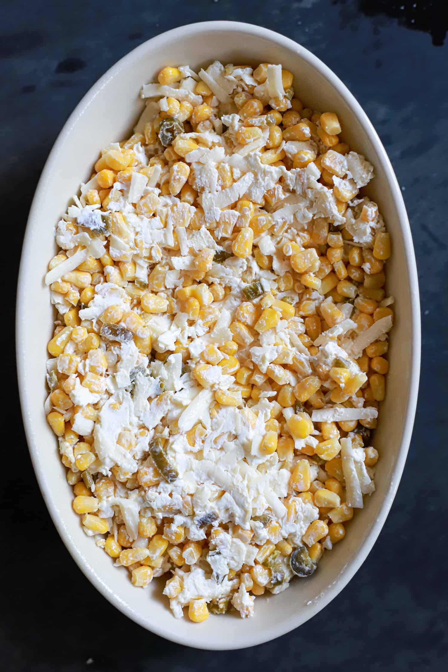 unbaked oval baking dish with philadelphia cream cheese corn dip mixture.