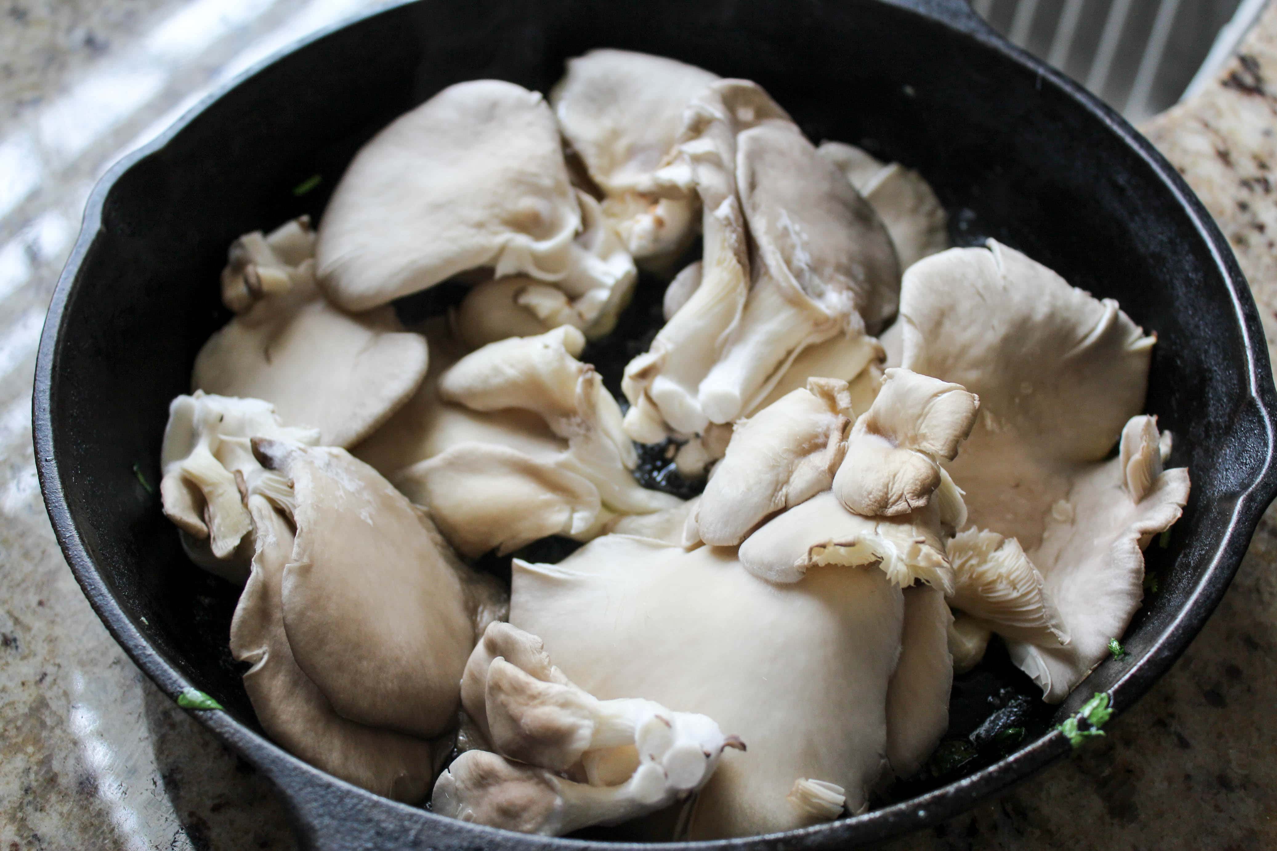 Oyster mushrooms in a cast iron skillet before being cooked.