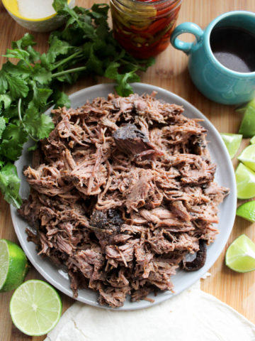 Round gray plate of shredded beef for tacos.