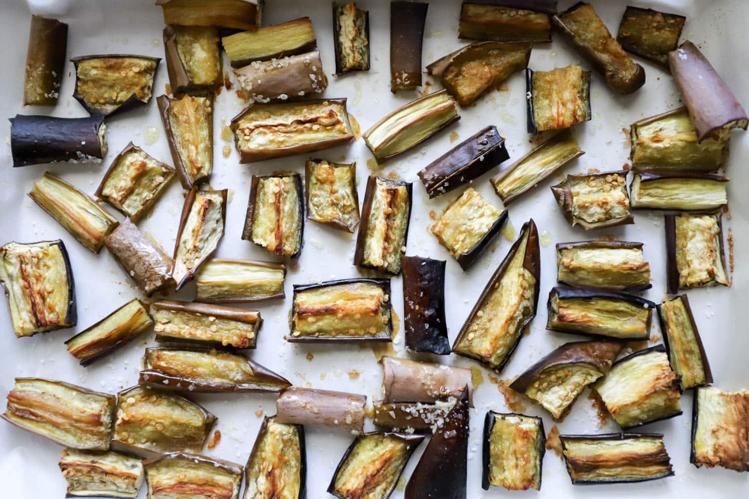 Roasted eggplant pieces on parchment paper.