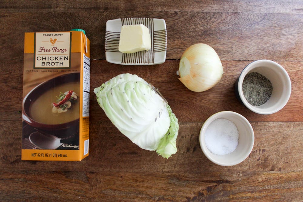 stewed cabbage ingredients on brown cutting board.