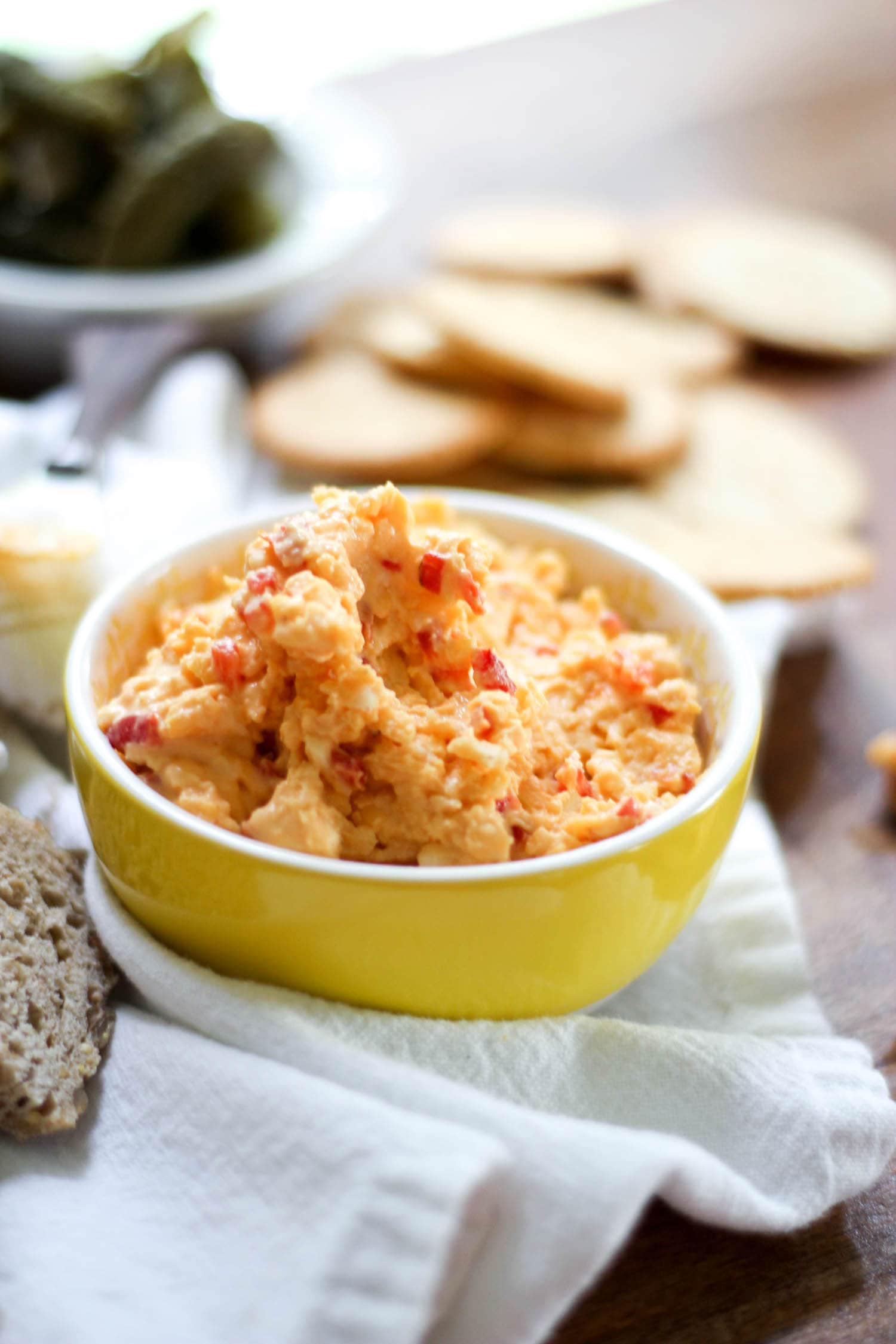 Small yellow bowl of pimento cheese made without cream cheese.