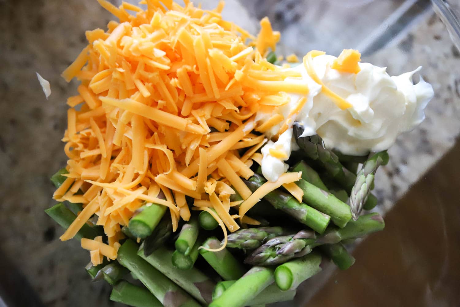 fresh asparagus with grated cheese in a glass bowl.