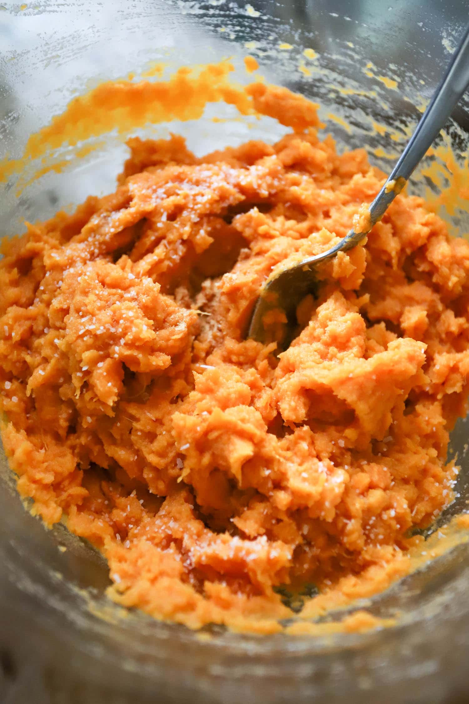 mashed sweet potatoes in a bowl sprinkled with kosher salt.