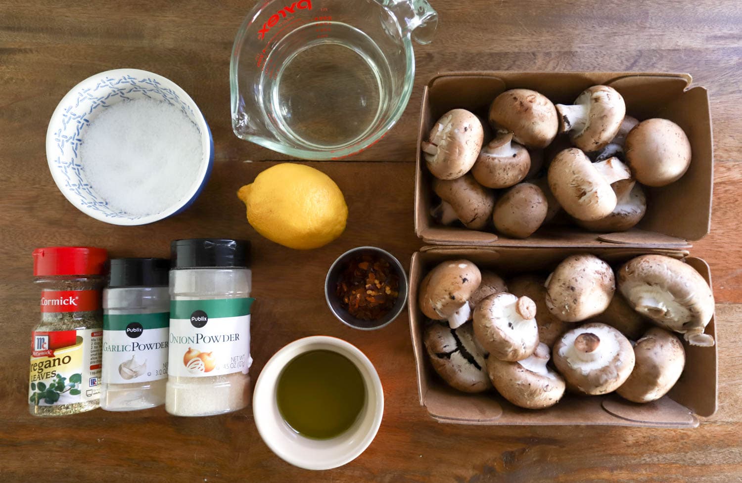 ingredients for marinated mushrooms over brown wooden board.