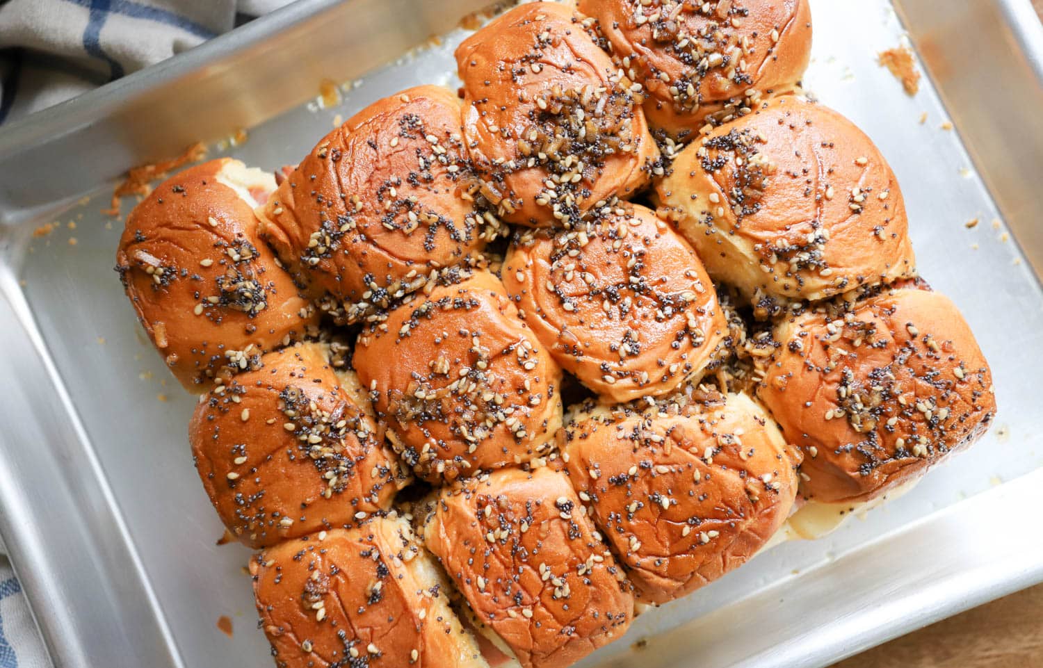 small baking sheet showing tops of ham delights with poppy seeds and sesame seeds.