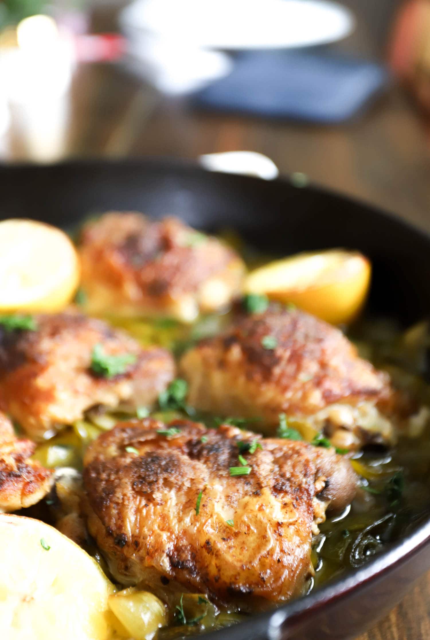 Braised Chicken Thighs with Leeks and Lemon side view in a large skillet.