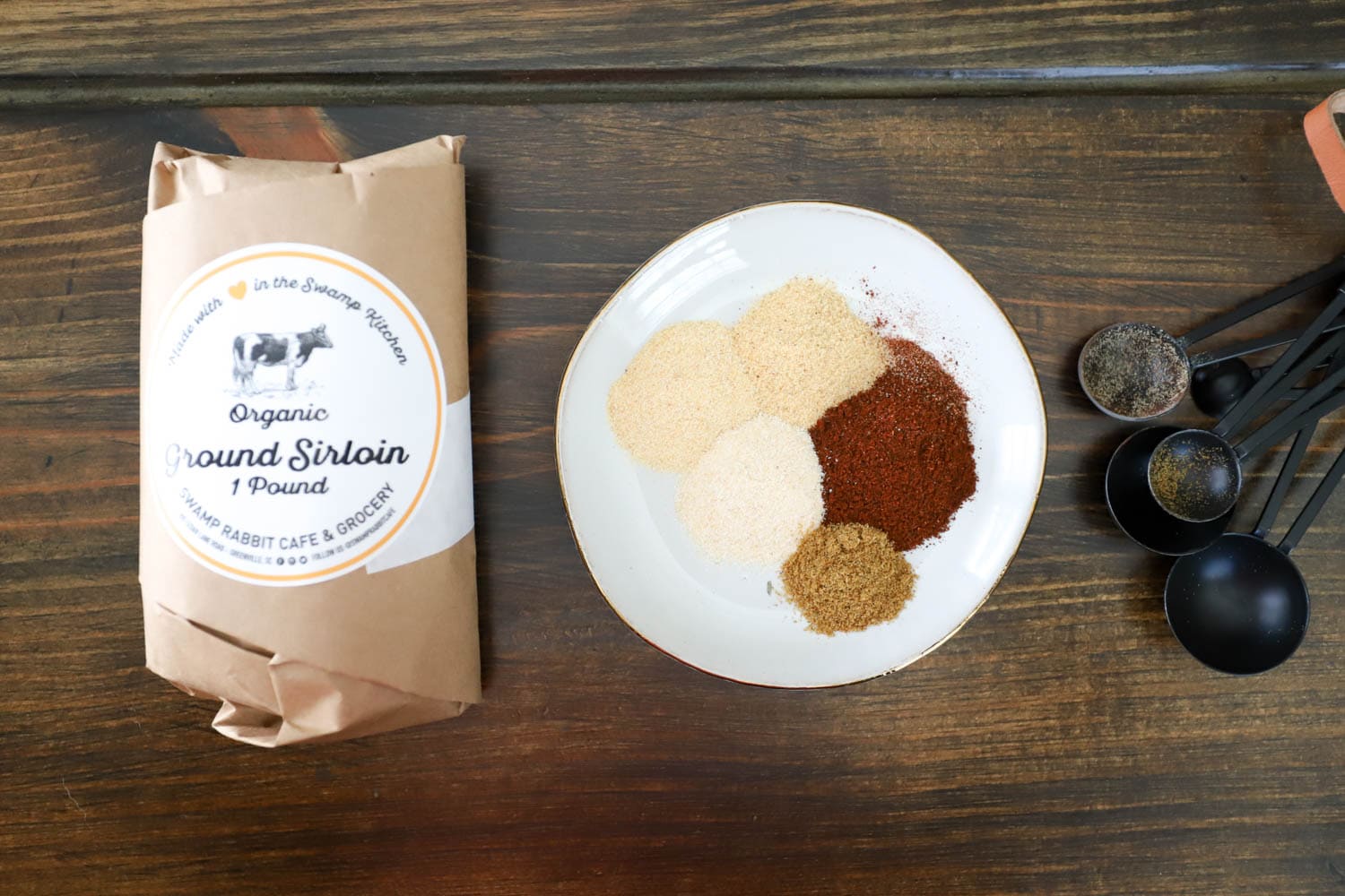 ingredients for homemade taco seasoning on brown board.